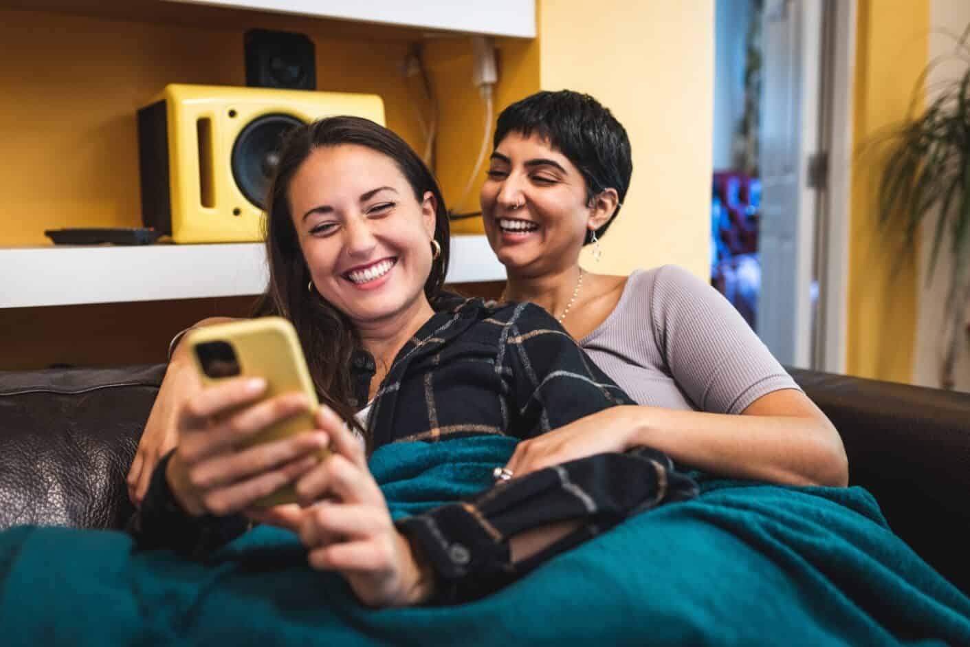 Own Homes ladies smiling looking at mobile phone